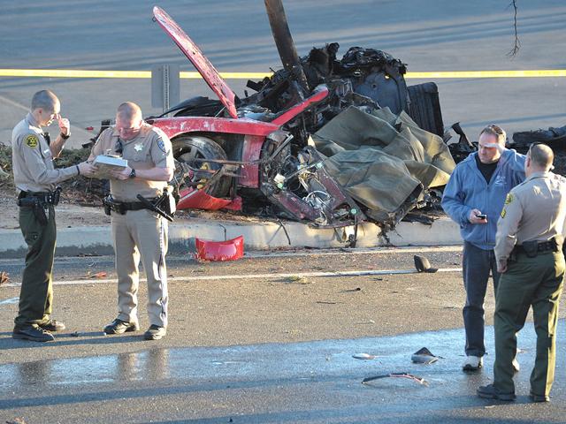 Sheriff’s deputies work near the wreckage of a Porsche that crashed into a light pole on Hercules Street near Kelly Johnson Parkway in Valencia, California. (AP Photo)