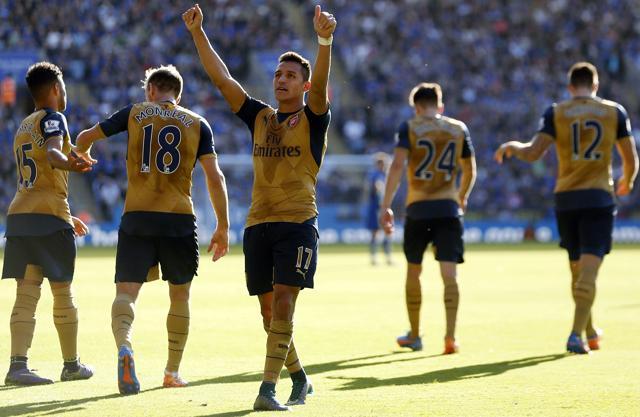 Alexis Sanchez, center, celebrates after completing his hat-trick against Leicester City. (AP Photo)