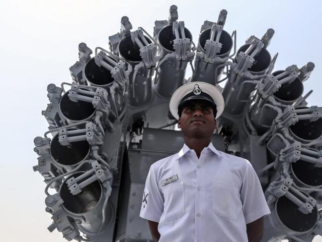 A naval officer poses for photographs in front of an indigenous rocket launcher during the media preview of the warship INS Kochi before commissioning it to the Indian Navy. According to reports, the INS Kochi is the second ship of the Kolkata-class (Project 15A) guided missile destroyers. (EPA Photo)