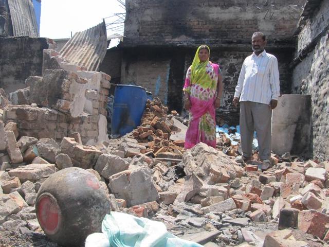 Parveen Momin and Mehboob Momin stand amid the ruins of their house that was attacked with petrol bombs by alleged activists of the Sri Rama Sene in Mudhol, Bagalkot.(HT Photo)