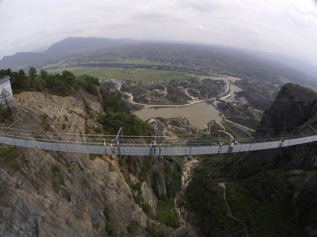 Visitors walk across a glass-bottomed suspension bridge as seen from the air in a scenic zone in Pingjiang county in southern China's Hunan province. (AP)