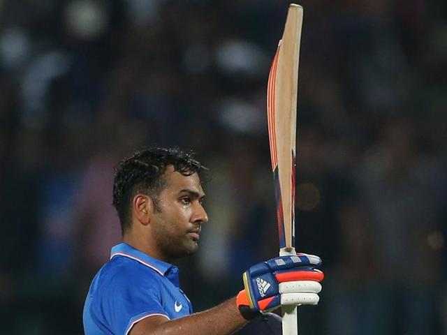 Rohit Sharma raises his bat in celebration after completing his century. (Reuters Photo)