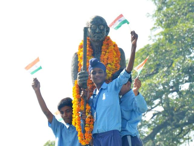 Students getting a picture with the Mahatma Gandhi’s statue in Amritsar on Friday. (Sameer Sehgal / HT)