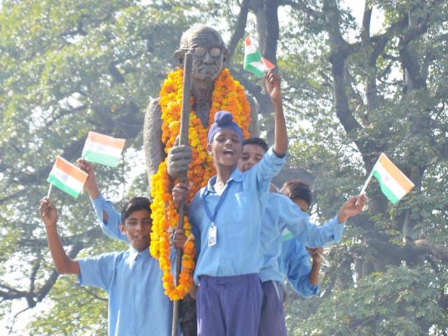Students of Nishkam Sewa Public School hold the tricolour as they pay tributes to Mahatma Gandhi on the occasion of Gandhi Jayant in Amritsar on Friday. (Sameer Sehgal / HT )