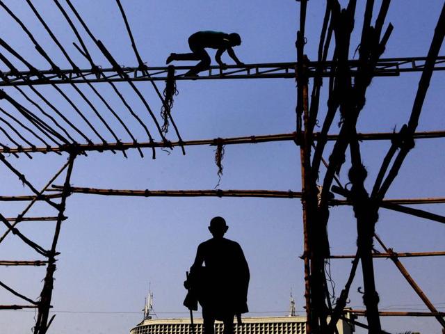 A man works to make a ‘pandal’ in front of the statue of Mahatma Gandhi, at Churchgate, Mumbai. (Pratham Gokhale/HT Photo) 