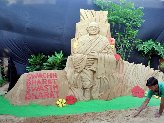 Sand artist Manas Kumar Sahoo creates a sculpture of Mahatma Gandhi, ahead of Gandhi Jayanti, at golden sea beach of Puri . (PTI Photo) 