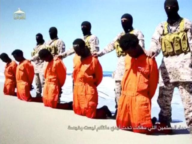 Islamic State militants stand behind what are said to be Ethiopian Christians along a beach in Wilayat Barqa, in this still image from an undated video made available on a social media website. (Reuters File Photo) Islamic State militants stand behind what are said to be Ethiopian Christians along a beach in Wilayat Barqa, in this still image from an undated video made available on a social media website. (Reuters File Photo)