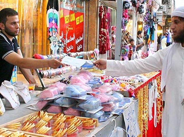 In this file photo provided by a website of the Islamic State group, an IS member, right, distributes pamphlets about in Mosul, northern Iraq. The Iraqi government has stopped paying wages, pensions to people of the cities under the control of the militant group, in order to stop their supplies from the locals. (AP File) In this file photo provided by a website of the Islamic State group, an IS member, right, distributes pamphlets about in Mosul, northern Iraq. The Iraqi government has stopped paying wages, pensions to people of the cities under the control of the militant group, in order to stop their supplies from the locals. (AP File)