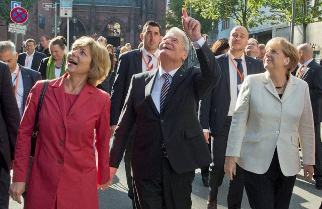 German President Joachim Gauck, center, his partner Daniela Schadt, left, and Chancellor Angela Merkel, right, walk through the city during celebrations marking the 25th anniversary of the German Unification in Frankfurt, on Saturday. (AP)