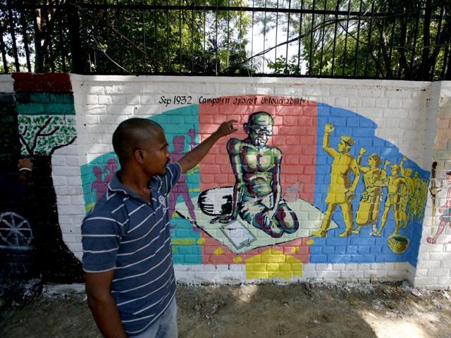 A student takes selfie with Mahatma Gandhi's graffiti near Delhi University on Mahatma Gandhi's 146th birth anniversary in New Delhi. (Ravi Choudhary/ HT photo)