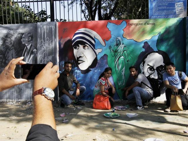 Students take their picture with Mahatma Gandhi’s graffiti near Delhi University on his 146th birth anniversary in New Delhi. (Ravi Choudhary/Ht photo)