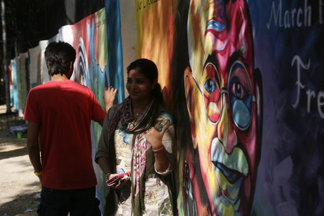 A student takes a selfie with Mahatma Gandhi’s paintings near Delhi University on Mahatma Gandhi ‘s 146th birth anniversary in New Delhi. (Ravi Choudhary/ HT photo)