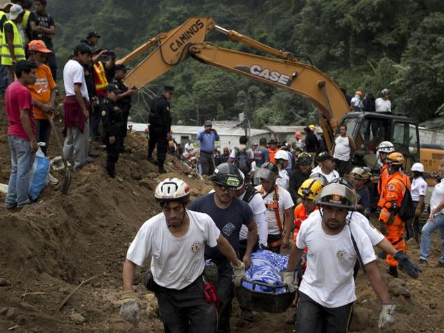 Rescuers carry a body recovered from the site of a landslide in Cambray, Guatemala City. The hill that towers over Cambray collapsed after heavy rains, burying several houses with dirt, mud and rocks. (AP Photo) Rescuers carry a body recovered from the site of a landslide in Cambray, Guatemala City. The hill that towers over Cambray collapsed after heavy rains, burying several houses with dirt, mud and rocks. (AP Photo)