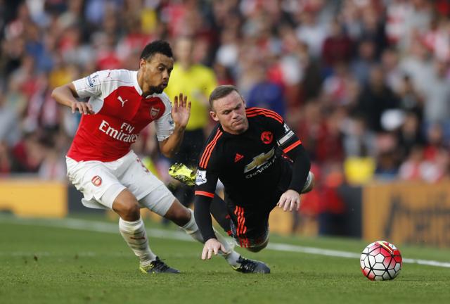 Manchester United's Wayne Rooney, right falls after a challenge by Arsenal's Francis Coquelin. (AP Photo)