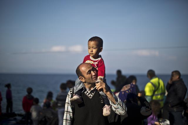 An Afghan refugee and his son stand in a resting point after arriving on a dinghy from the Turkish coast to the northeastern Greek island of Lesbos. (AP)