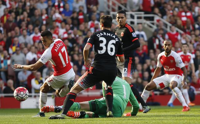 Arsenal's Alexis Sanchez, left looks round as he scores the opening goal of the game during the English Premier League soccer match between Arsenal and Manchester United at Emirates stadium in London, Sunday. (AP Photo)