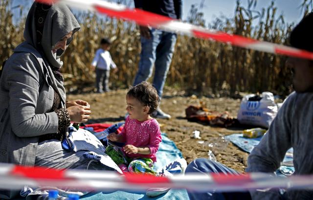 Migrants rest during their journey to cross the border from Serbia to Croatia. (REUTERS)