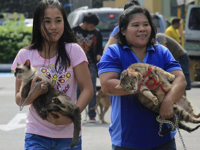 People carry their pets before the start of a pet blessing at Greenhills shopping mall in Manila . (REUTERS)
