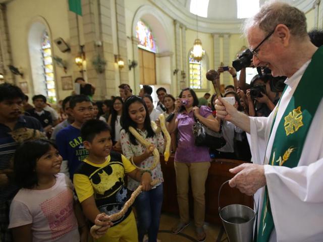 Kids even got their snakes to be blessed by the priest. (AP)