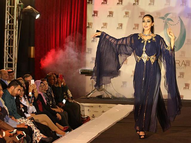A model in an ink-blue flowing gown by a local designer during the Basra Fashion Night… (AFP)
