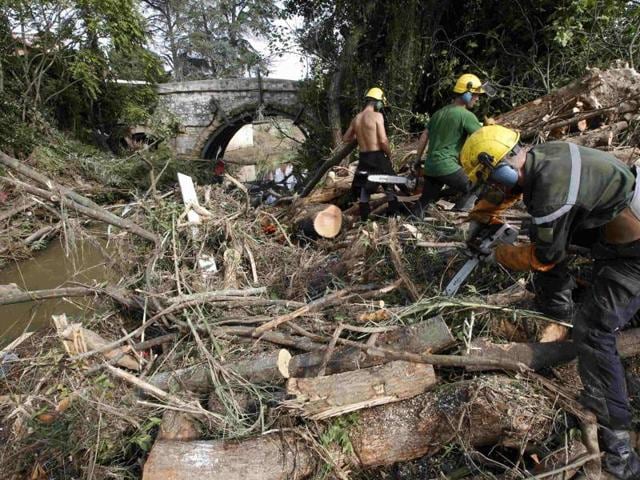 Men saw trees near a stream as they clear away debris the day after torrential rains caused flooding in Biot, France, October 5, 2015. (REUTERS Photo) Men saw trees near a stream as they clear away debris the day after torrential rains caused flooding in Biot, France, October 5, 2015. (REUTERS Photo)