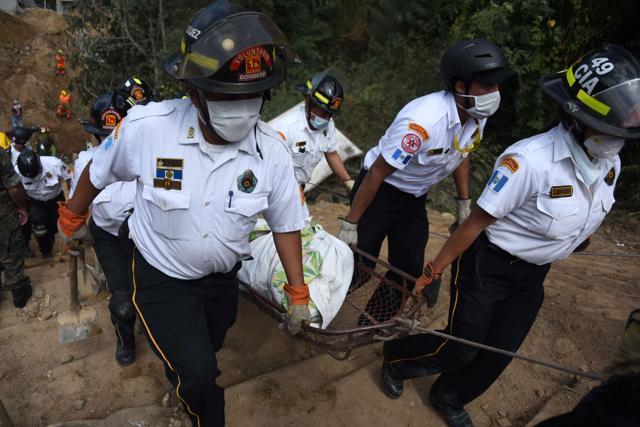 Firemen carry a body recovered from the debris in the village of El Cambray II, in Santa Catarina Pinula municipality, some 15 km east of Guatemala City, on October 4, 2015 after a landslide late Thursday struck the village. (AFP)