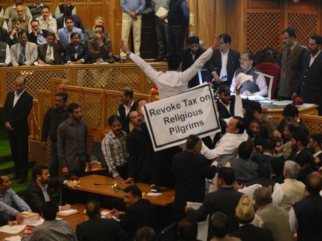 As a minister from the Mufti cabinet started discussion in the House, the opposition legislators jumped into the well and raised slogans against the government. (Waseem Andrabi/HT )