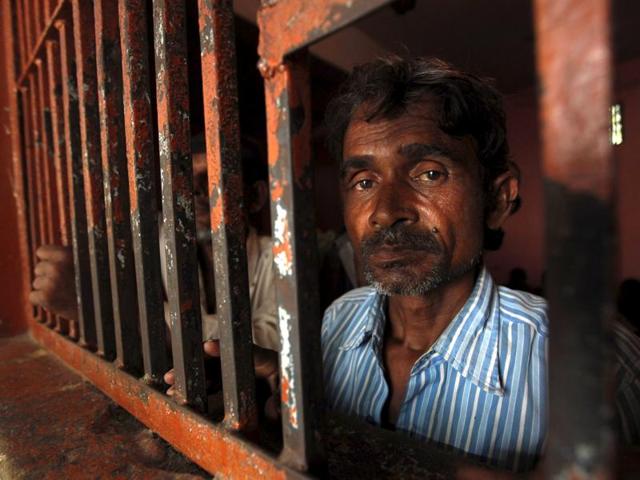 An Indian fisherman looks on from behind the bars of his cell at a police station in Karachi. (REUTERS)