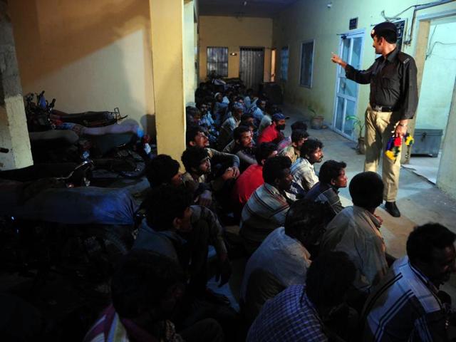 A Pakistani policeman counts arrested Indian fishermen at a police station in Karachi. (AFP)