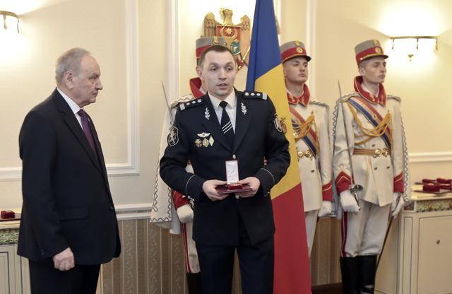 In this May 31, 2015 photo provided by Constantin Malic, former Moldova Police investigator Malic holds an award received from President Nicolae Timofti, left, in Chisinau, Moldova. (AP Photo) In this May 31, 2015 photo provided by Constantin Malic, former Moldova Police investigator Malic holds an award received from President Nicolae Timofti, left, in Chisinau, Moldova. (AP Photo)