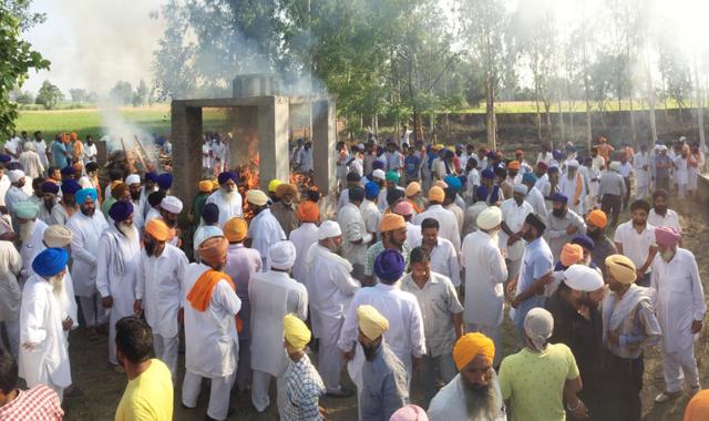 People gather around the funeral pyre of those killed in road accident truck. (HT Photo) People gather around the funeral pyre of those killed in road accident truck. (HT Photo)