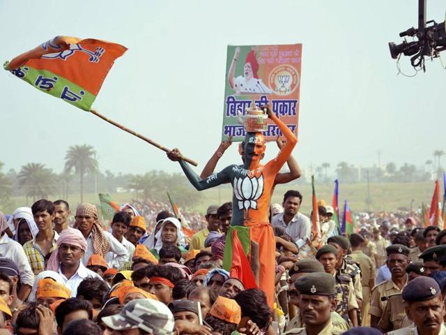 A BJP supporter waves the party flag during an election campaign rally addressed by Prime Minister Narendra Modi at Banka in Bihar. (REUTERS)
