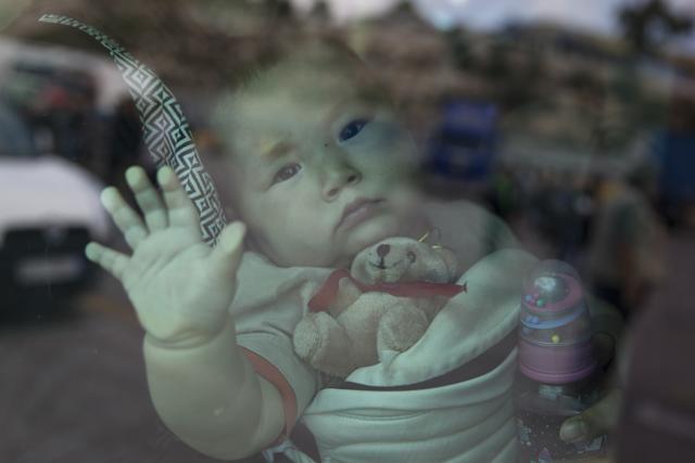 A child looks out from a window after her arrival aboard a ferry from the Greek island of Lesbos at the Athens' port of Piraeus. (AP) A child looks out from a window after her arrival aboard a ferry from the Greek island of Lesbos at the Athens' port of Piraeus. (AP)