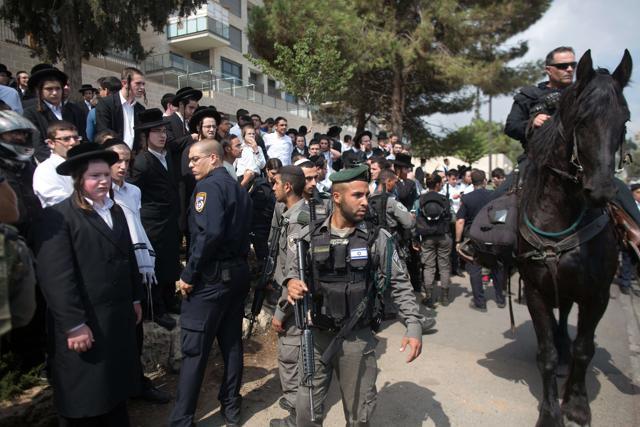 Ultra-Orthodox Jews look on as Israeli police control the scene after a Palestinian man stabbed a Jewish teenager in Jerusalem on October 9, 2015. (AFP Photo) Ultra-Orthodox Jews look on as Israeli police control the scene after a Palestinian man stabbed a Jewish teenager in Jerusalem on October 9, 2015. (AFP Photo)