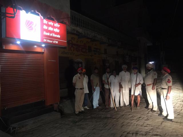 Cops along with villagers outside an ATM kiosk in Phillaur. (HT Photo) Cops along with villagers outside an ATM kiosk in Phillaur. (HT Photo)