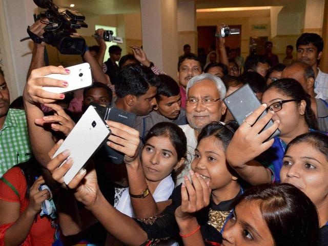 Bihar chief minister Nitish Kumar poses for a selfie with girls during a programme on Bihar elections in Patna. (PTI)