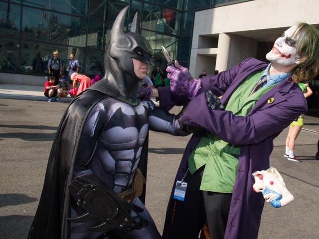 Attendees dressed as Batman and the Joker mock fight outside the Javits Center. (AP)