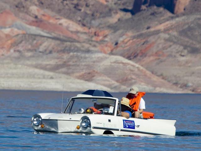 Another white German-made Amphicar on its way to the Hoover dam during the show. (REUTERS)