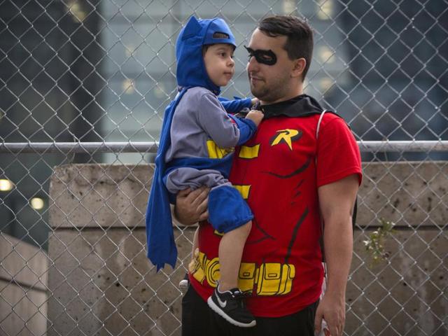 Asher Luise is held by Marcus Luise as both dressed as Batman and Robin at the NYCC. (REUTERS)