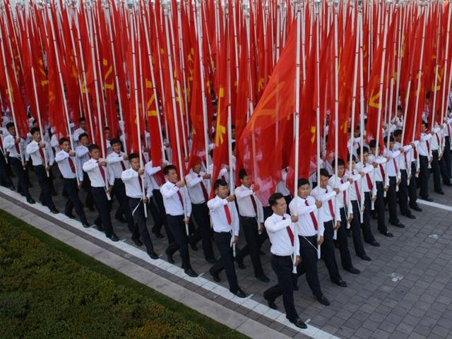 Participants hold flags as they pass through Kim Il-Sung square during a mass military parade in Pyongyang. Isolated North Korea marked the 70th anniversary of its ruling Workers' Party on Saturday with a massive military parade overseen by leader Kim Jong Un, who said his country was ready to fight any war waged by the United States. (AFP)
