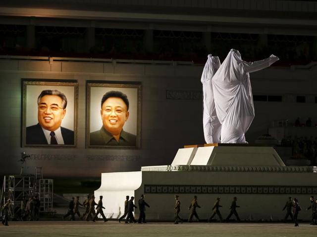 Large covered statues of North Korea's founder Kim Il-sung and former leader Kim Jong-il are wheeled past their portraits after the parade celebrating the 70th anniversary of the founding of the ruling Workers' Party of Korea. (REUTERS)