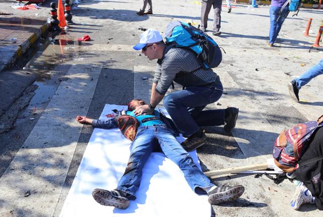 A man gives first aid following an explosion at the main train station in Turkey's capital Ankara, on October 10, 2015. At least 30 people were killed in twin explosions in Turkey's capital Ankara. (AFP Photo)