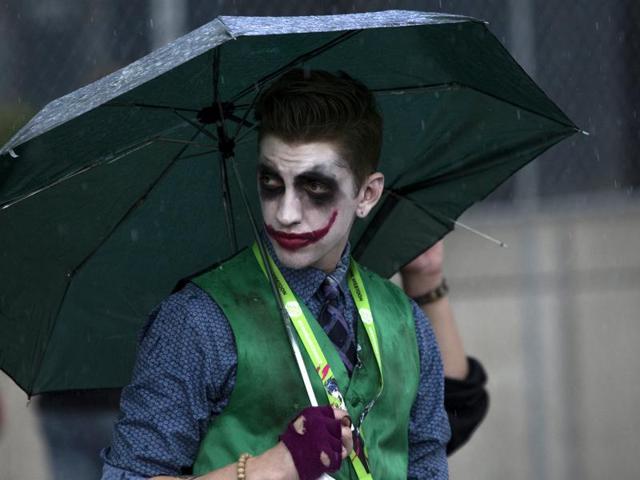 A man dressed as "The Joker" uses an umbrella as rain falls on day two of New York Comic Con in Manhattan. (REUTERS)