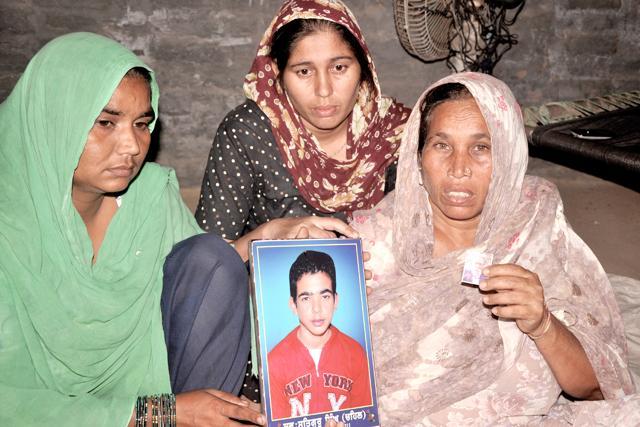 Daughters and wife of Bikkar Singh of Kheeva Khurd village in Mansa show the picture of Bikkar and his son, Satguru, who had committed suicide 4 years back. (Sanjeev Sharma/HT)