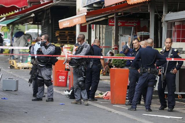 Israeli police stand next to the body of a dead Palestinian assailant at the spot where he stabbed two Israeli Jews, before was shot dead outside Jerusalem's Old City. (Reuters Photo) Israeli police stand next to the body of a dead Palestinian assailant at the spot where he stabbed two Israeli Jews, before was shot dead outside Jerusalem's Old City. (Reuters Photo)