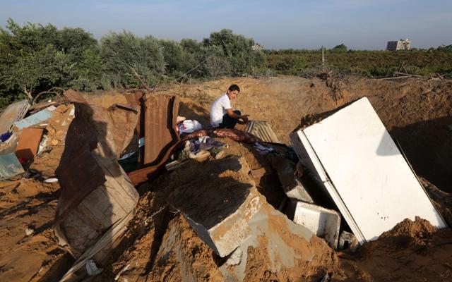 A Palestinian boy inspects the damage after an Israeli retaliatory air strike demolished the house of a Palestinian family on October 11 in the Zeitun sector south of Gaza City. A pregnant Palestinian woman and her toddler daughter were killed in the air strike while three others were still trapped under the home's ruins, medical sources said. (AFP) A Palestinian boy inspects the damage after an Israeli retaliatory air strike demolished the house of a Palestinian family on October 11 in the Zeitun sector south of Gaza City. A pregnant Palestinian woman and her toddler daughter were killed in the air strike while three others were still trapped under the home's ruins, medical sources said. (AFP)