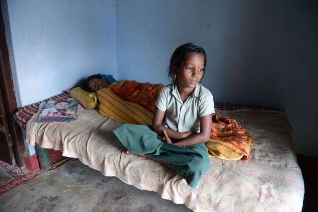 Tribal child P Chitti, who lost her father in a road accident, sits at her home in the village of Peddakunta. (AFP) Tribal child P Chitti, who lost her father in a road accident, sits at her home in the village of Peddakunta. (AFP)