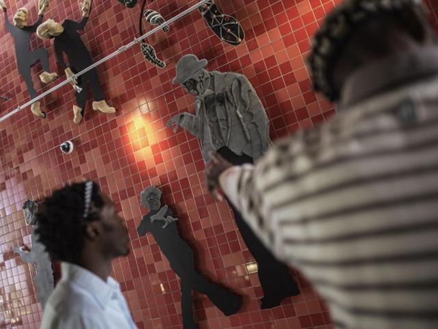 South African artist Lehlohonolo Mkhasibe (R) points at a collective artwork done for the Soweto Theatre in Soweto, South Africa. He is a member of Ubuhle Bobuntu ("beauty of humanity" in Zulu), a group of artists that uses recycled materials and experimental techniques to express their own lives in modern SA. (AFP/ Gianluigi Guercia) South African artist Lehlohonolo Mkhasibe (R) points at a collective artwork done for the Soweto Theatre in Soweto, South Africa. He is a member of Ubuhle Bobuntu ("beauty of humanity" in Zulu), a group of artists that uses recycled materials and experimental techniques to express their own lives in modern SA. (AFP/ Gianluigi Guercia)