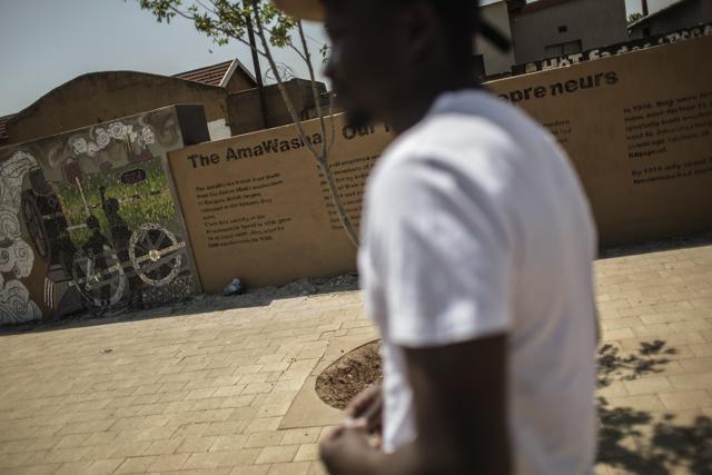 Mkhasibe (R) points at a collective artwork done for the Soweto Theatre in Soweto, South Africa. (AFP/ Gianluigi Guercia) Mkhasibe (R) points at a collective artwork done for the Soweto Theatre in Soweto, South Africa. (AFP/ Gianluigi Guercia)
