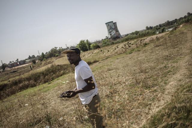 Gojo holds the cow dung he uses for his artwork near the cooling towers of Orlando Power Station Soweto. (AFP/ Gianluigi Guercia) Gojo holds the cow dung he uses for his artwork near the cooling towers of Orlando Power Station Soweto. (AFP/ Gianluigi Guercia)